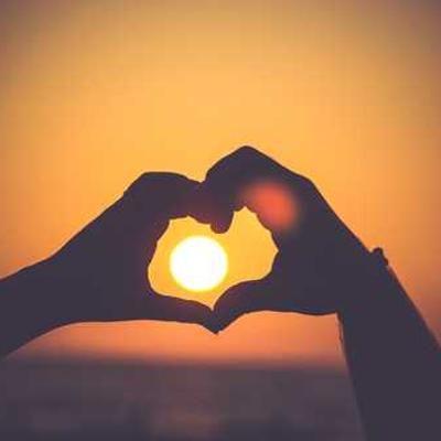 Two hands creating a heart and showing the sun